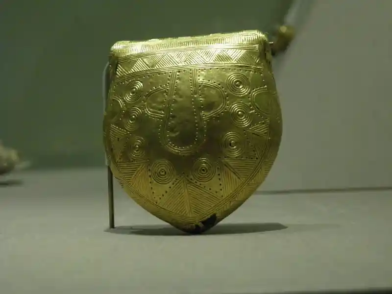 Phallic design with solar disc, gold-covered amulet